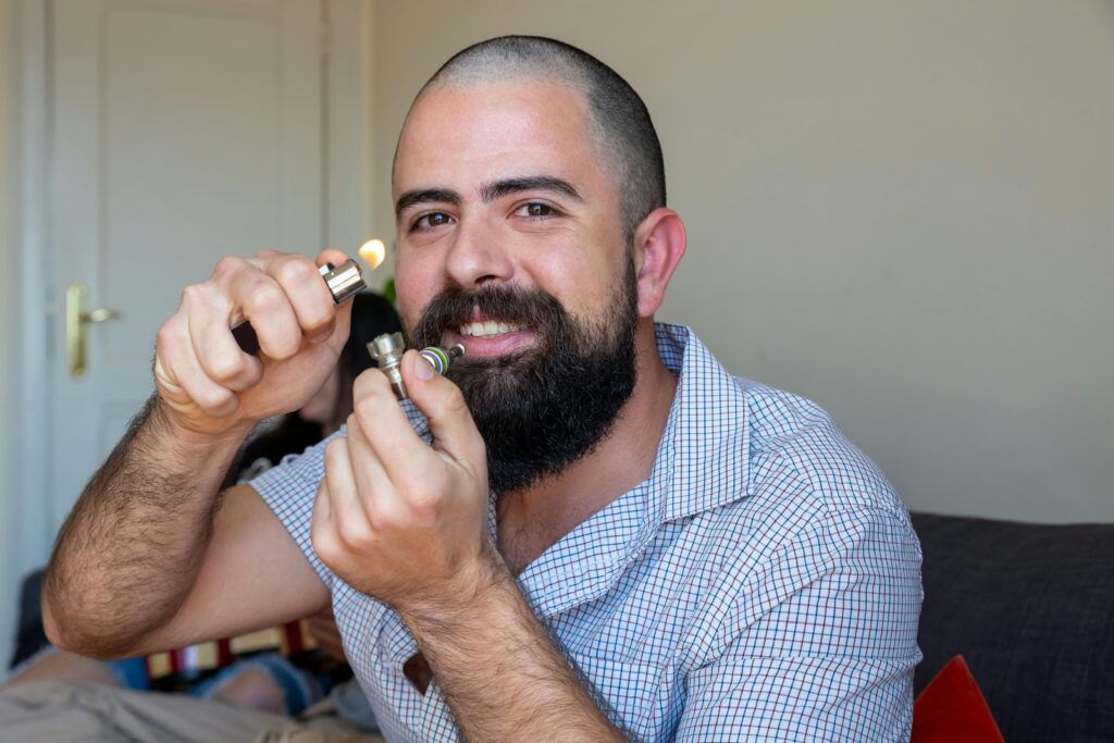 pexels-photo-7928148-7928148 Bearded man lighting a pipe indoors, showcasing lifestyle and relaxation in Portugal.